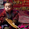  Młody kirgiski chłopiec wykorzystuje zaaferowanie dorosłych weselem do zabawy z chlebem